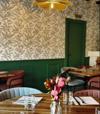Intérieur de restaurant élégant avec papier peint feuillu, boiseries vertes et tables dressées à Bonnétable dans la Sarthe 72