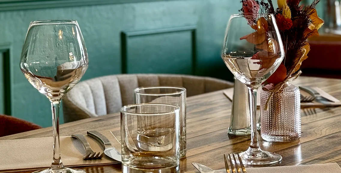 Deux verres à vin, deux verres à eau et un arrangement floral sur une table en bois à Bonnétable dans la Sarthe 72