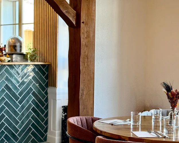 Intérieur de restaurant moderne avec bar carrelé vert et table en bois dressée à Bonnétable dans la Sarthe 72