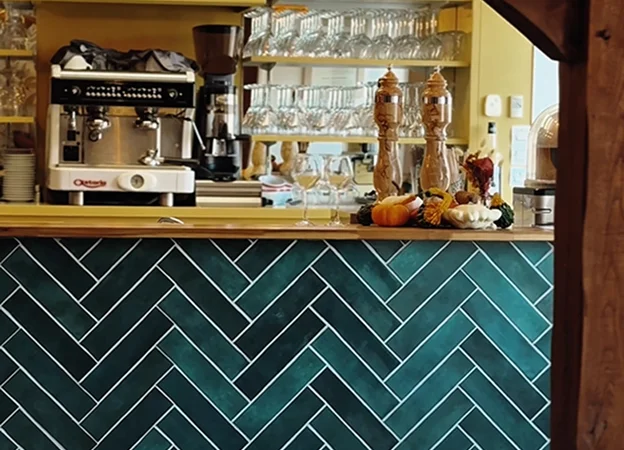 Comptoir de bar carrelé en chevrons vert sarcelle avec machine à expresso et verres à Bonnétable dans la Sarthe 72